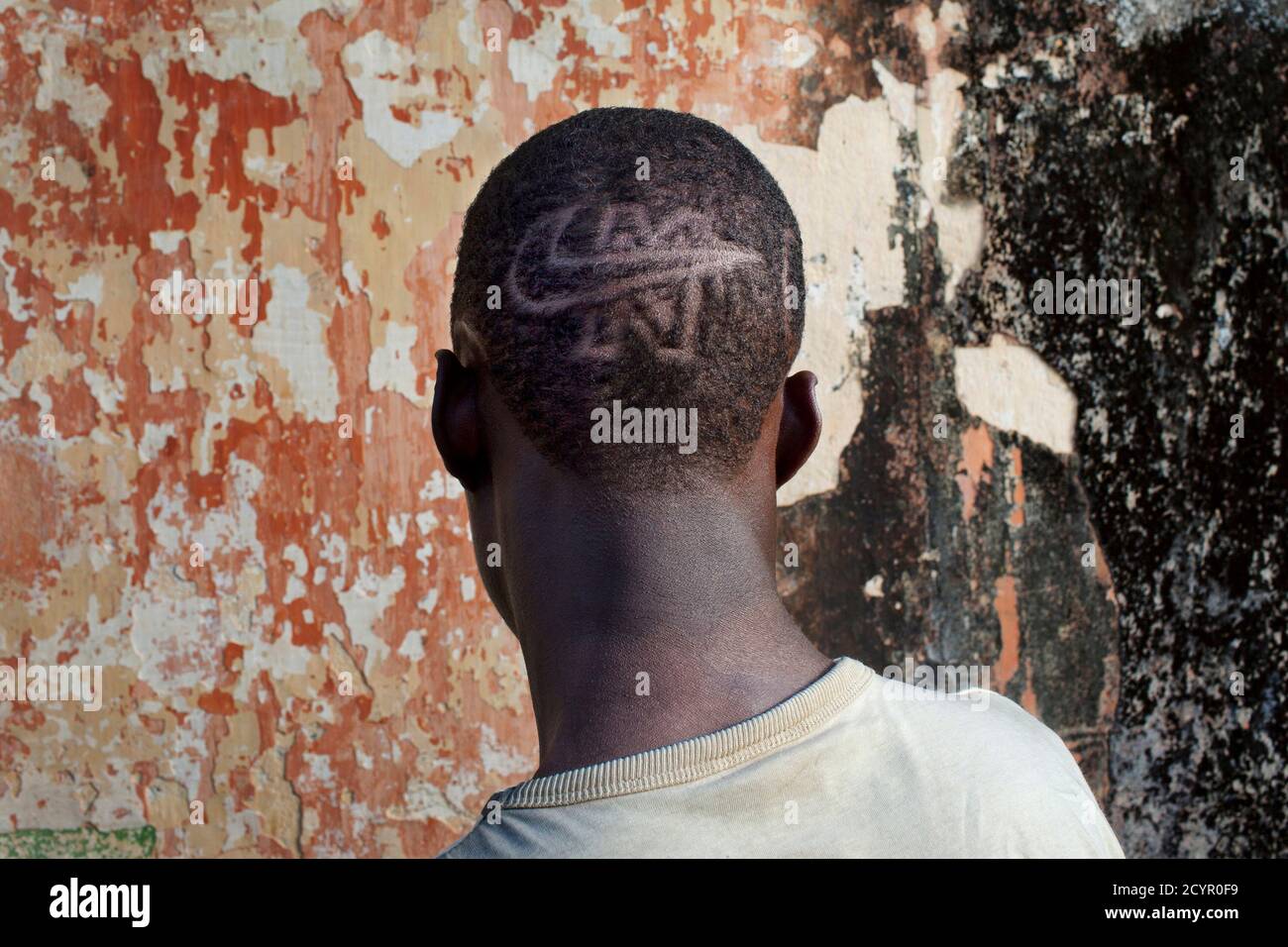 L'étudiant Samba montre un logo Nike rasé dans ses cheveux devant un ancien  bâtiment administratif colonial portugais à Cacheu, en Guinée-Bissau, le 27  octobre 2012. Photo prise le 27 octobre 2012. REUTERS/JOE