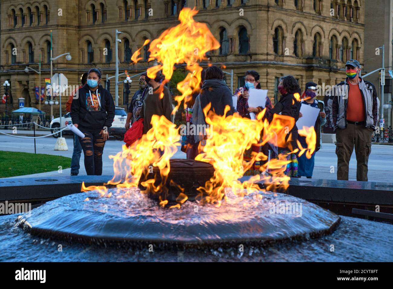 Derrière Centennial Flame Burning, des gens à Vigil pour la femme des Premières nations Joyce Echaquan qui est décédée à l'hôpital plus tôt cette semaine Banque D'Images