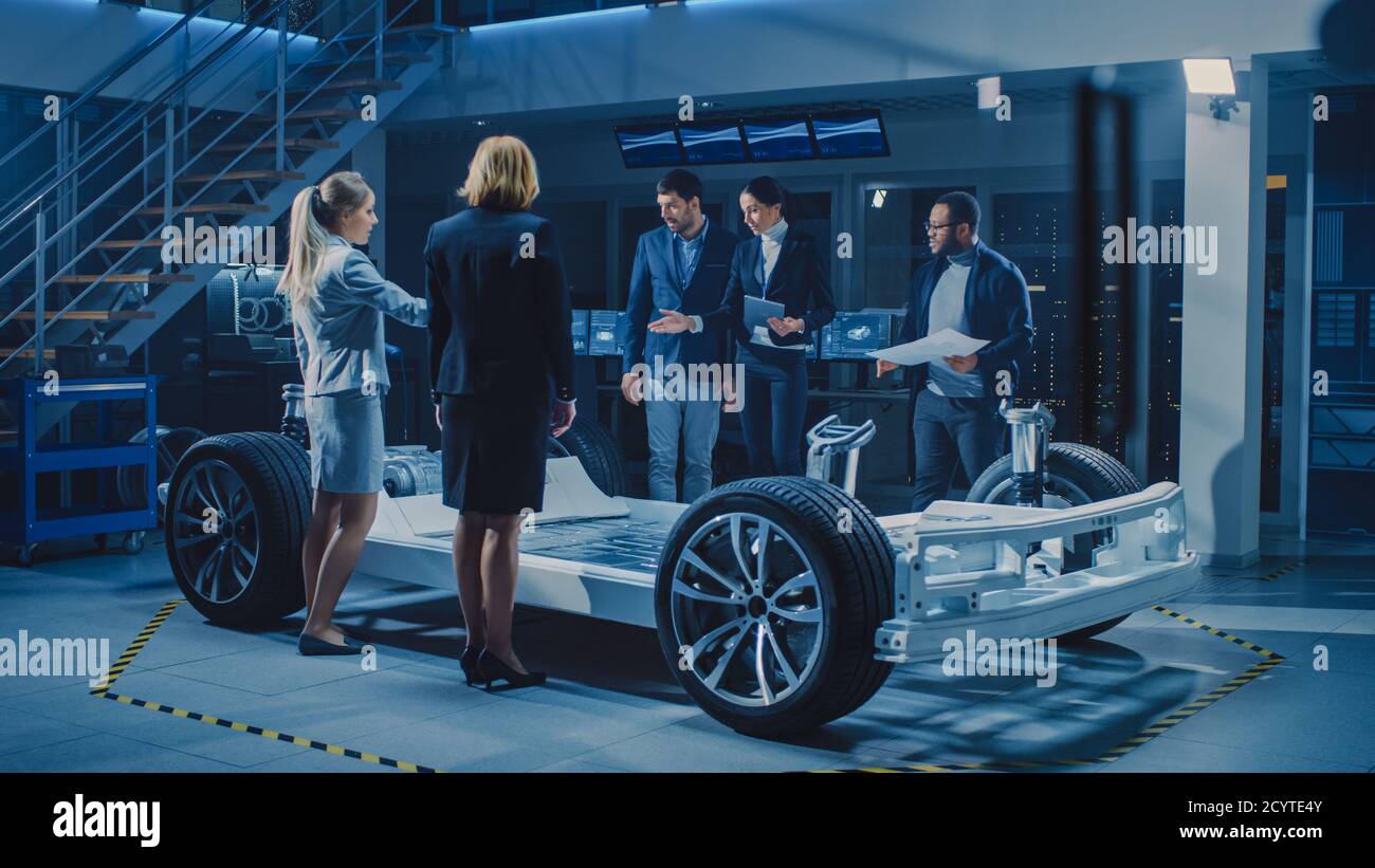 Une équipe diversifiée d'ingénieurs concepteurs d'automobiles présente l'électricité autonome futuriste Châssis de plateforme de voiture à un groupe d'investisseurs et d'hommes d'affaires Banque D'Images