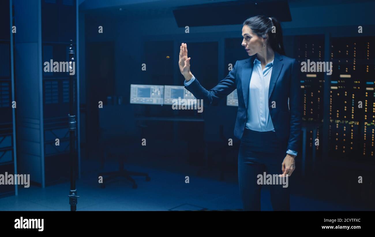 Dans le laboratoire moderne de recherche de centre de données belle confiante femme fait la réalité virtuelle activant le geste tactile. Maquette de prise de vue en réalité augmentée. Banque D'Images