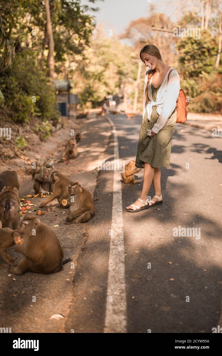 Femme de voyage caucasienne avec peu de singes actifs intelligents dans le sauvage Banque D'Images
