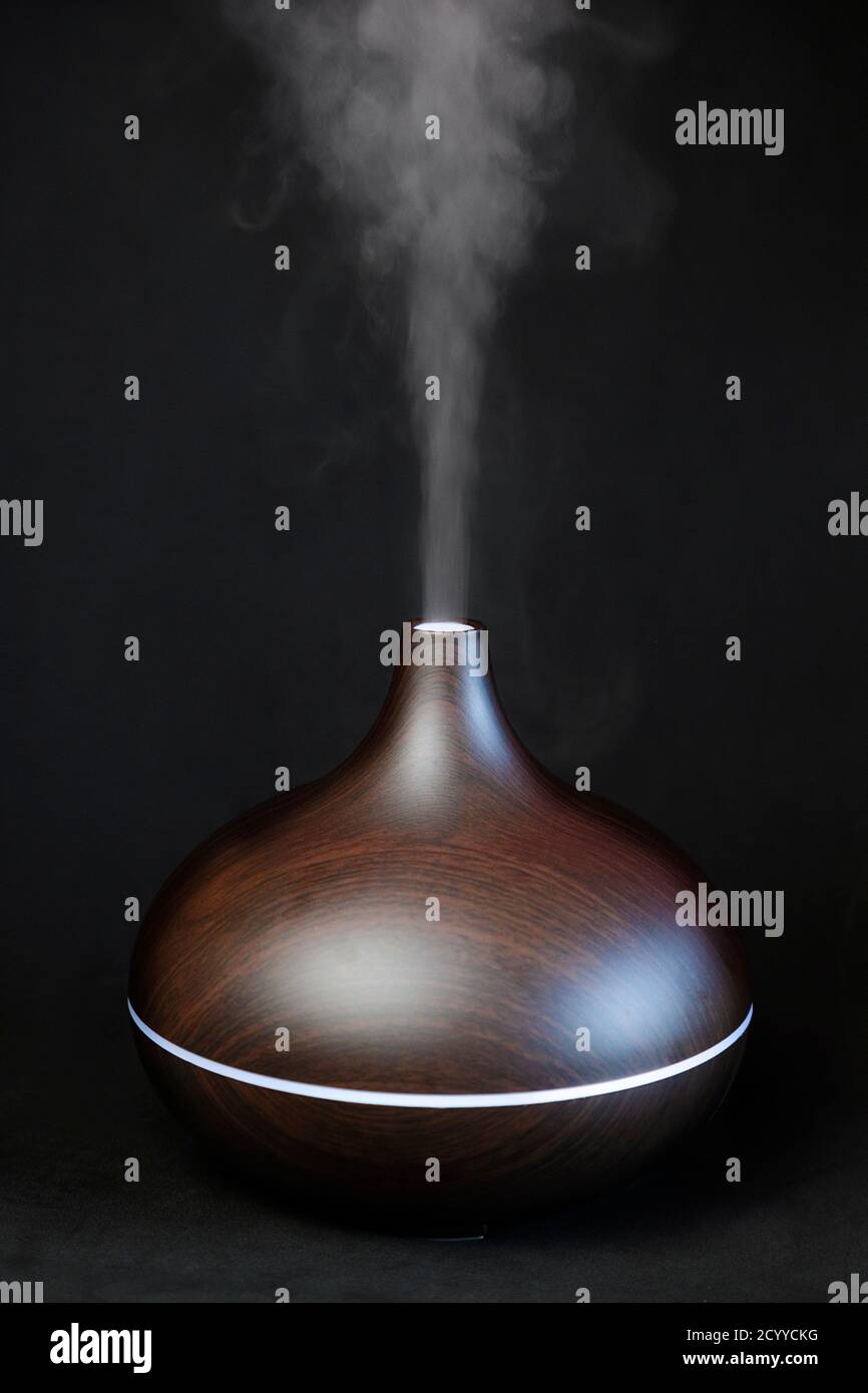 Diffuseur d'huile aromatique sur fond noir Banque D'Images