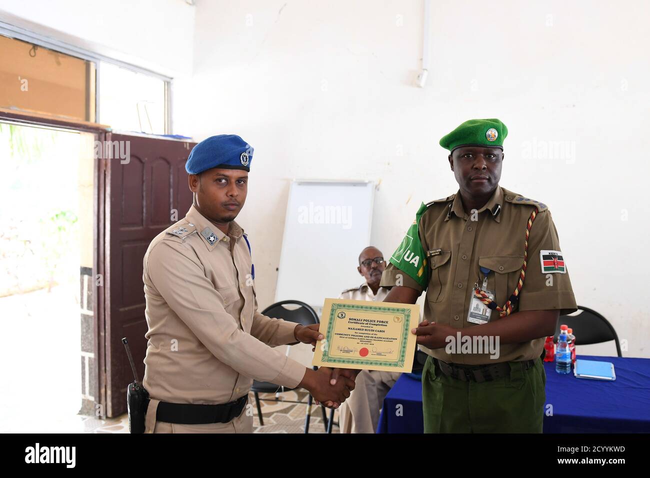 Le 27 juillet 2019, SSP Francis Ndiema, Coordonnateur de la formation et de la planification pour la police de l’AMISOM, a présenté des certificats aux policiers lors de la séance de clôture d’un atelier sur la police de proximité et la déradicalisation qui s’est tenu à l’École de police générale Kahiye à Mogadiscio, en Somalie. Banque D'Images