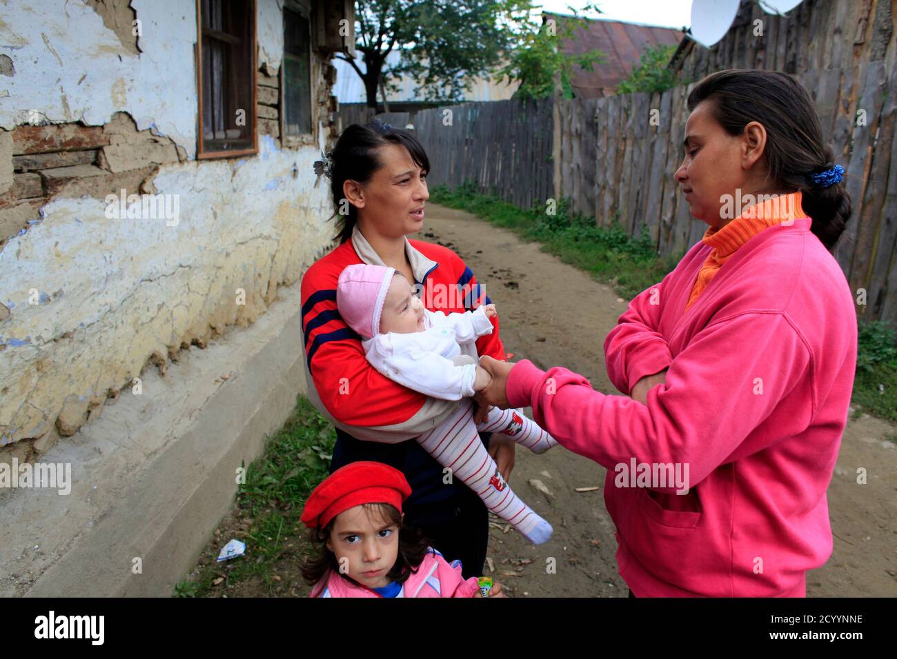 Roma women with children chat on a street in Prislop village, 300 km (184  miles) northwest of Bucharest where the majority of Roma people craft  brooms and baskets made from twigs September