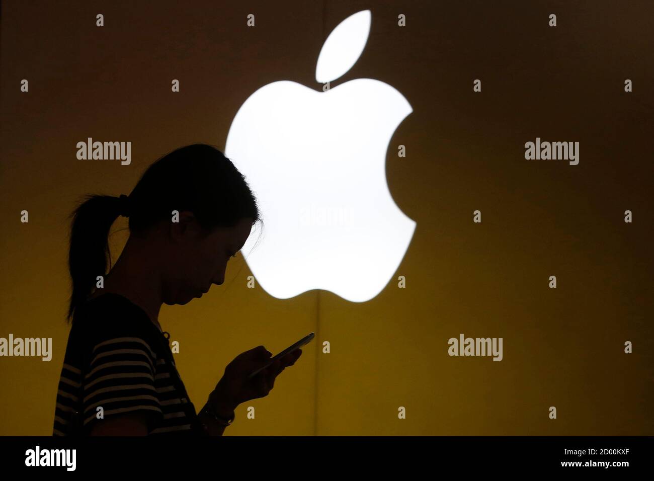 A woman looks at the screen of her mobile phone in front of an Apple logo outside its store in downtown Shanghai September 10, 2013. Apple Inc is expected to introduce a A woman looks at the screen of her mobile phone in front of an Apple logo outside its store in downtown Shanghai September 10, 2013. Apple Inc is expected to introduce a