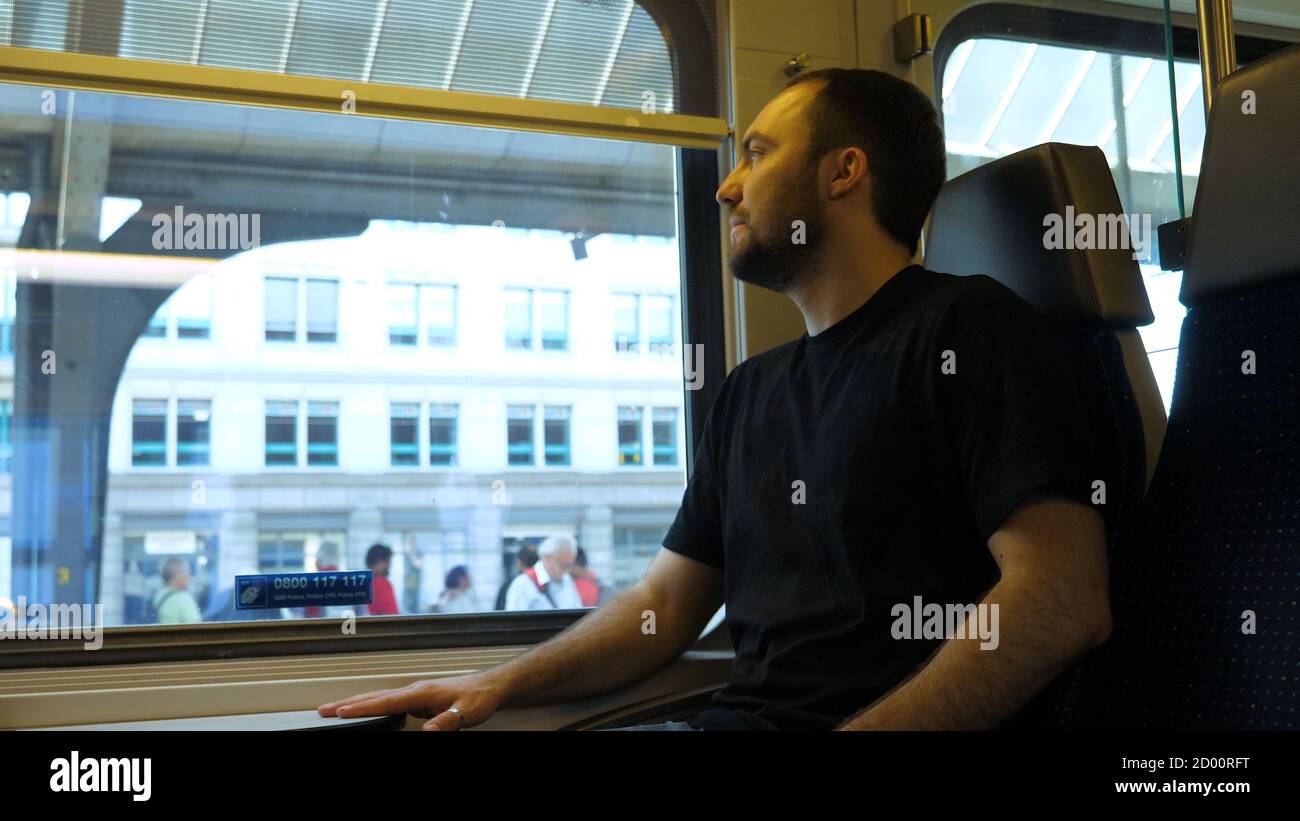 Un jeune homme prend place dans un train. Banque D'Images