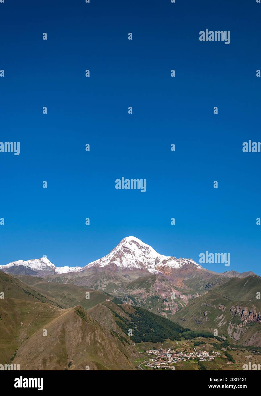 Le mont Kazbek (5047m), le village de l'église de trinité Gergeti Gergeti et dans les montagnes du Caucase du nord de la Géorgie. Banque D'Images