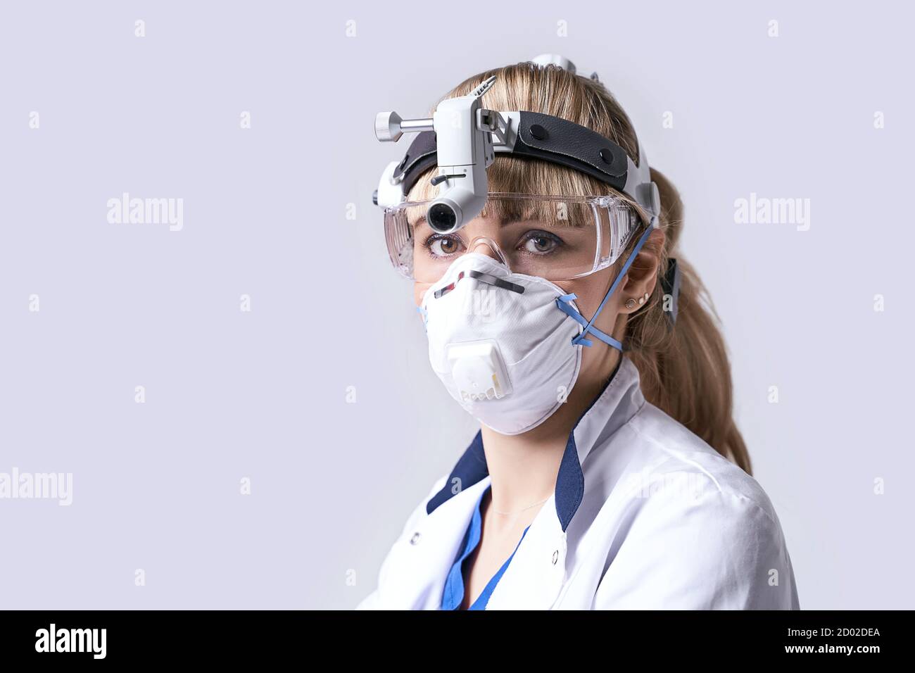 Médecin ORL confiant portant un phare chirurgical et des lunettes de protection. Portrait d'une otolaryngologiste féminine ou d'un chirurgien de la tête et du cou Banque D'Images
