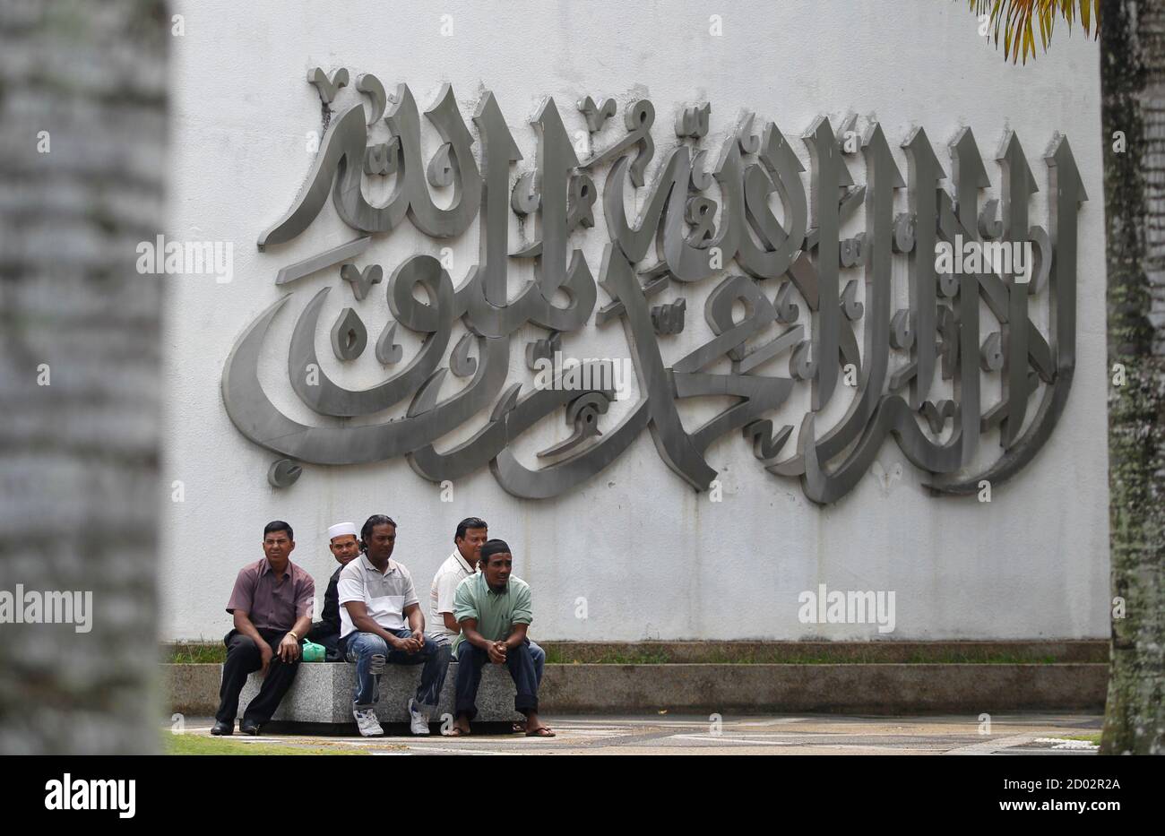 Ethnic Rohingyas From Myanmar And Living In Malaysia Wait For A Prayer Next To A Display Of Koranic Verses That Say I Bear Witness That There Is No God But Allah And Ethnic Rohingyas From Myanmar And Living In Malaysia Wait For A Prayer Next To A Display Of Koranic Verses That Say I Bear Witness That There Is No God But Allah And