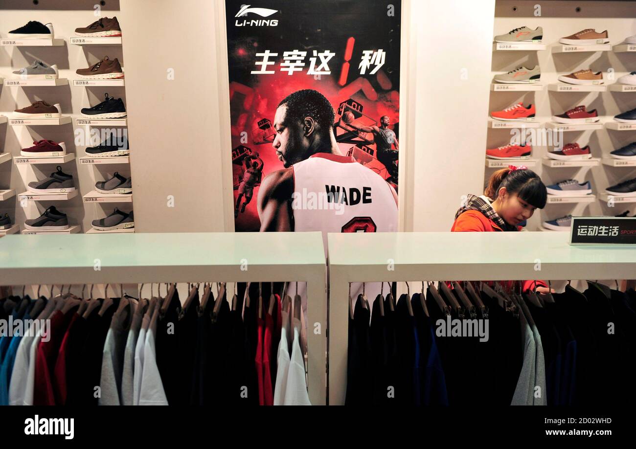 A customer shops at a Li Ning sportswear store in front of a poster of NBA  basketball player Dwyane Wade in Shenyang, Liaoning province March 21,  2013. China's biggest sportswear brand, Li