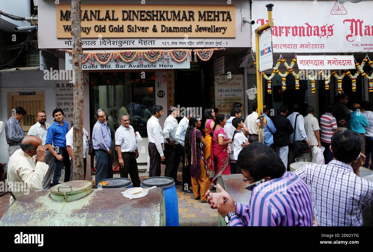 Customers stand in line to buy silver biscuits outside a jewellery showroom  on the occasion of Dhanteras, a Hindu festival associated with Lakshmi, the  goddess of wealth, at a market in Mumbai