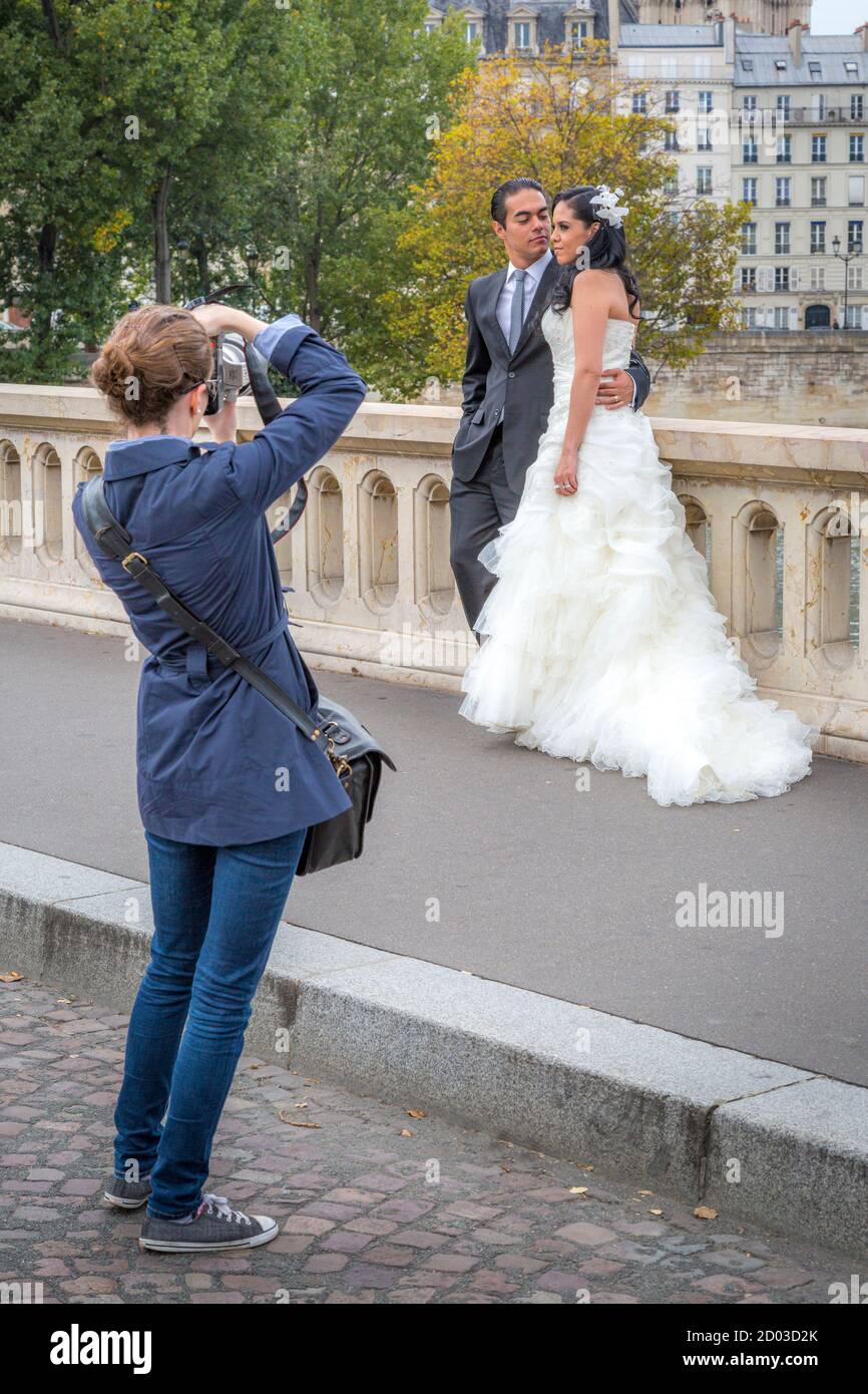 Couple de mariage posant pour des photos le long de Pont Marie, Paris, France Banque D'Images
