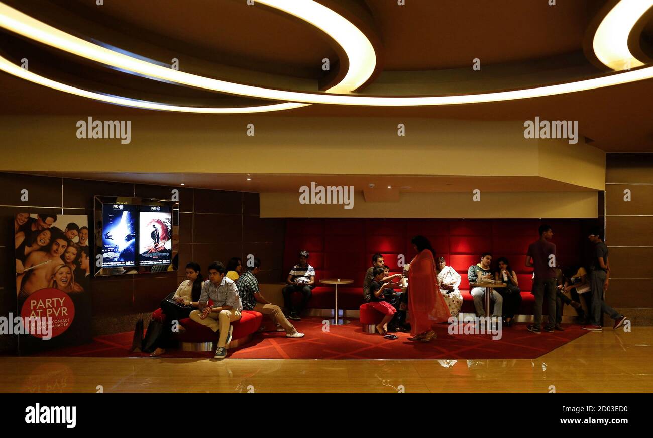 Cinema-goers wait at the lobby of a PVR Multiplex in Mumbai ...