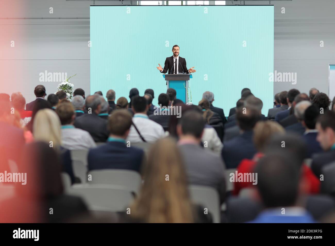 Personnes assises dans une salle de conférence et un homme à l'intérieur un costume donnant un discours Banque D'Images