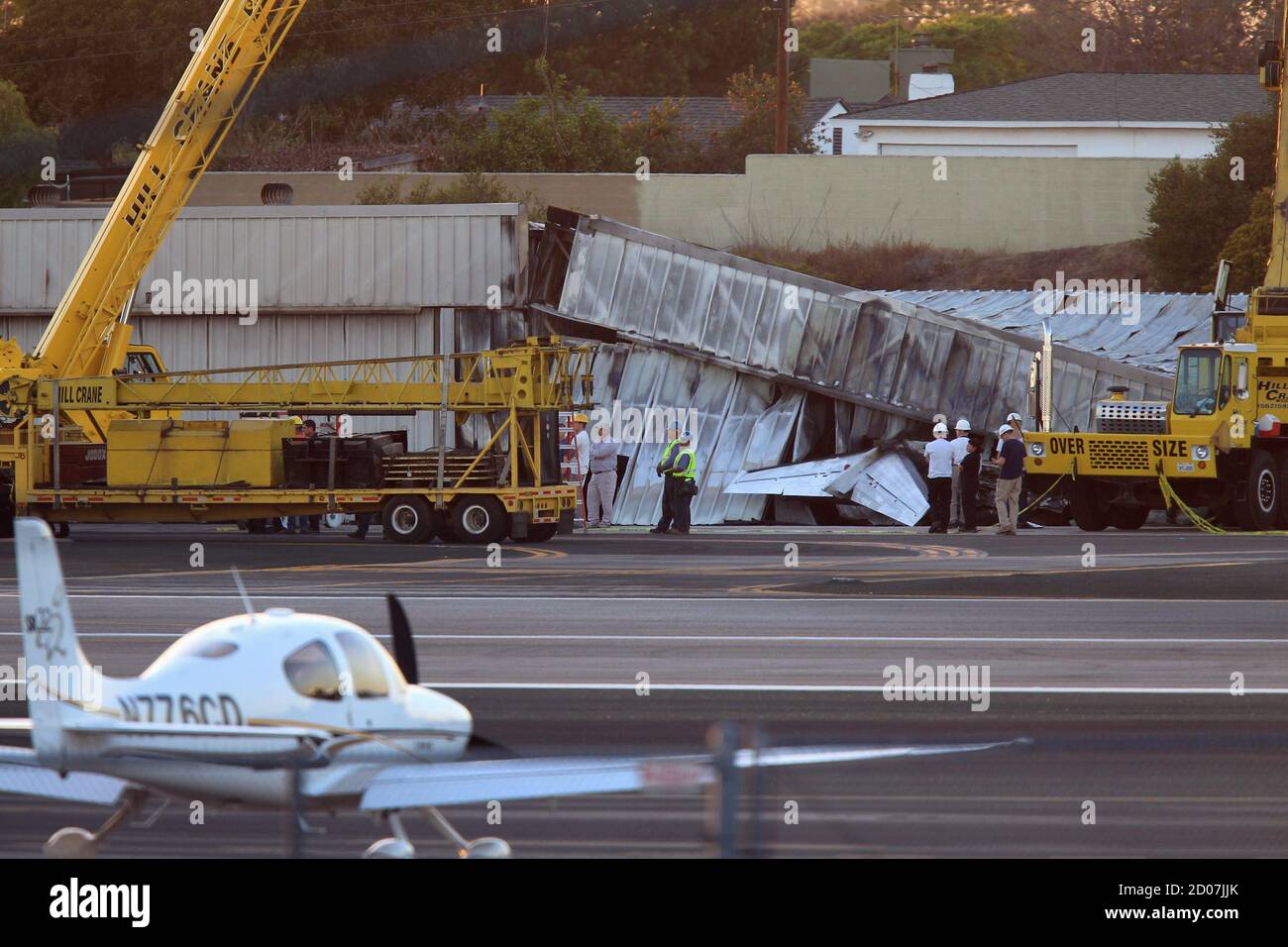 Workers Stand Near The Wreckage Of A Twin Engine Cessna Citation 525a Aircraft Before It Is Extracted From Inside A Collapsed Hangar It Slammed Into And Burst Into Flames After It Touched Down