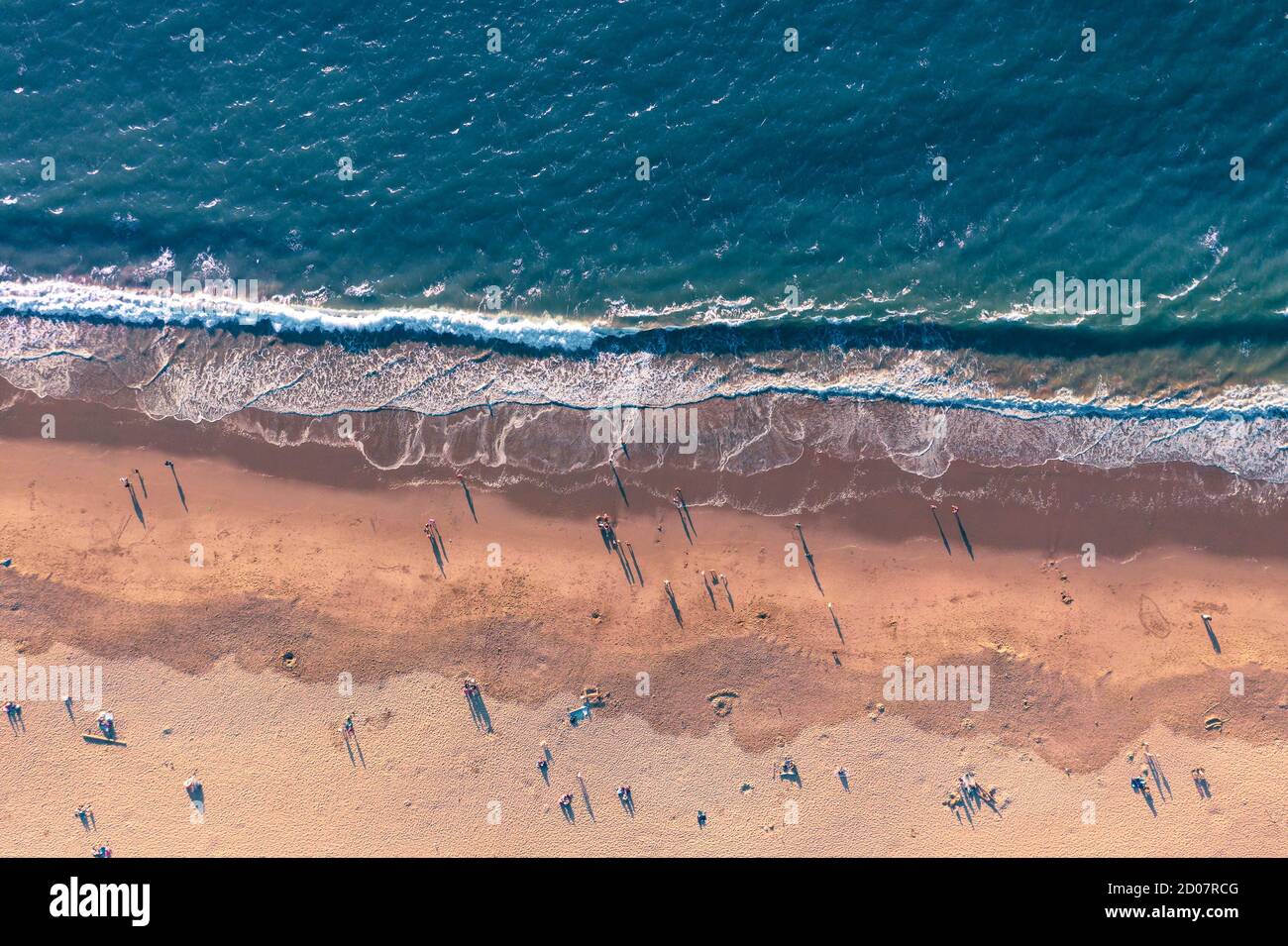 Vue aérienne vers le bas des personnes appréciant la plage au coucher du soleil en Californie, États-Unis Banque D'Images