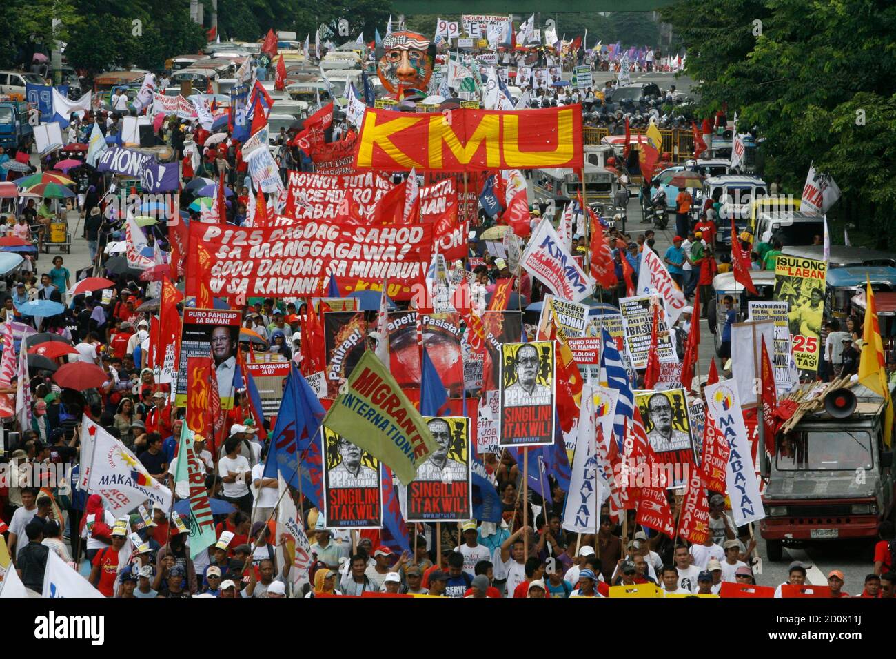 Protesters carry banners and placards as they march along a busy street  during a rally outside the Batasan Complex in Quezon city, metro Manila  July 23, 2012, where Philippines President Benigno Aquino