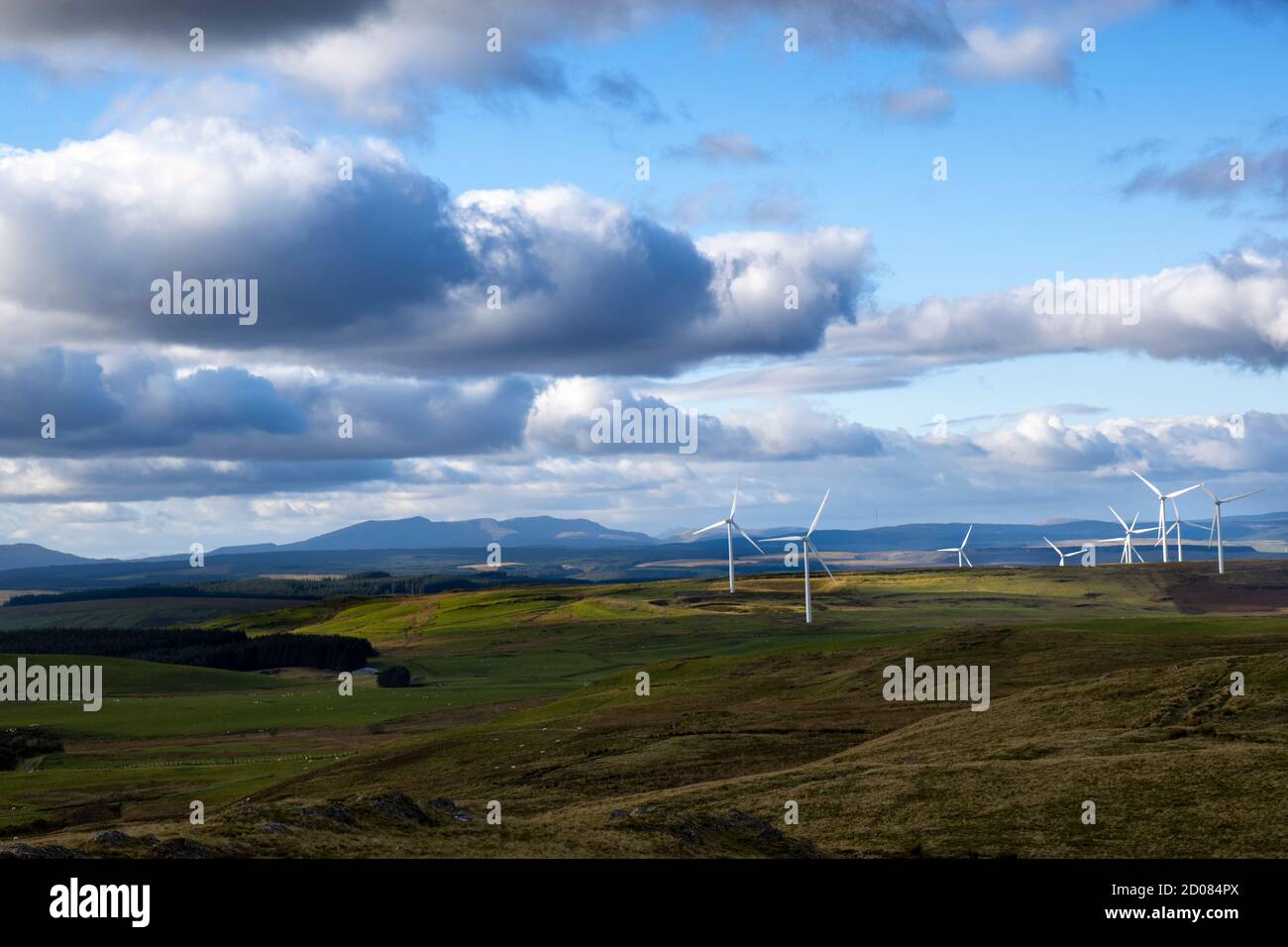 Vue depuis le sommet de la montagne près de Caersws of certaines éoliennes éclairées par la lumière du soleil dans le distance Banque D'Images