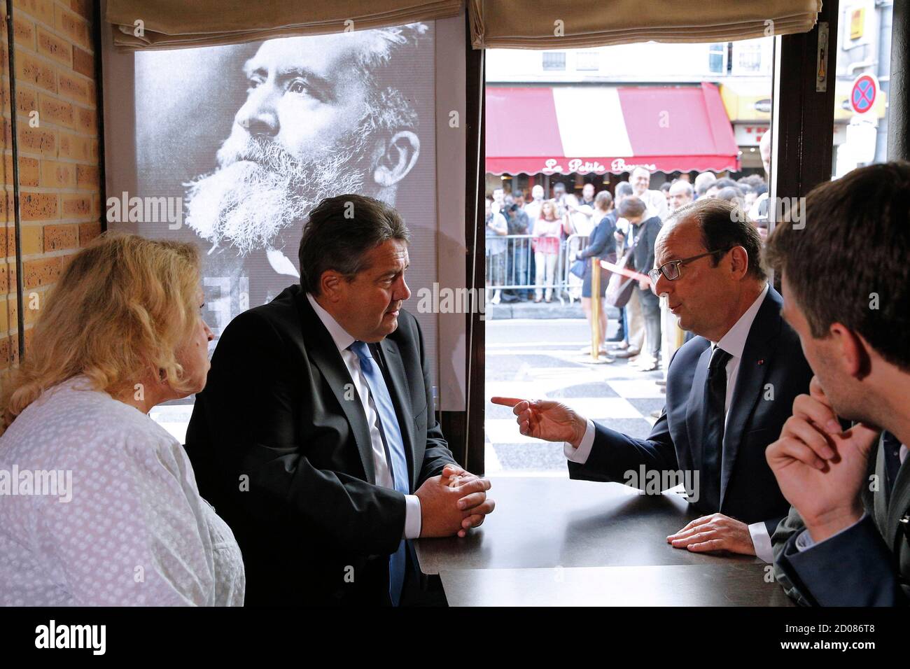 French President Francois Hollande (R) talks with German Minister for Economic Affairs and Energy Sigmar Gabriel inside 'La Taverne du Croissant' Cafe in Paris, July 31, 2014 after a ceremony to commemorate