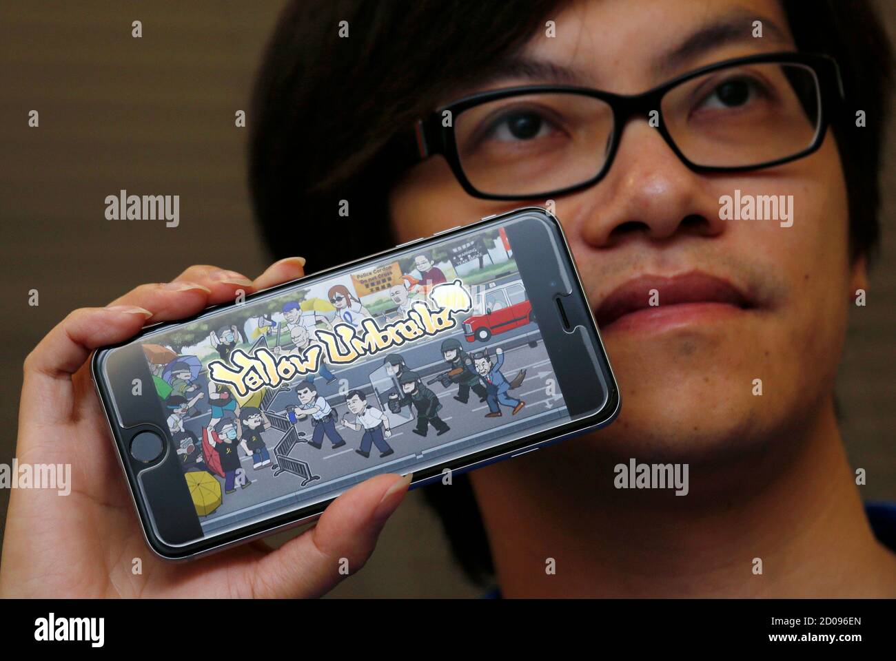 CEO of Hong Kong- based app-development company Awesapp Fung Kam Keung  poses with the opening scene of his 