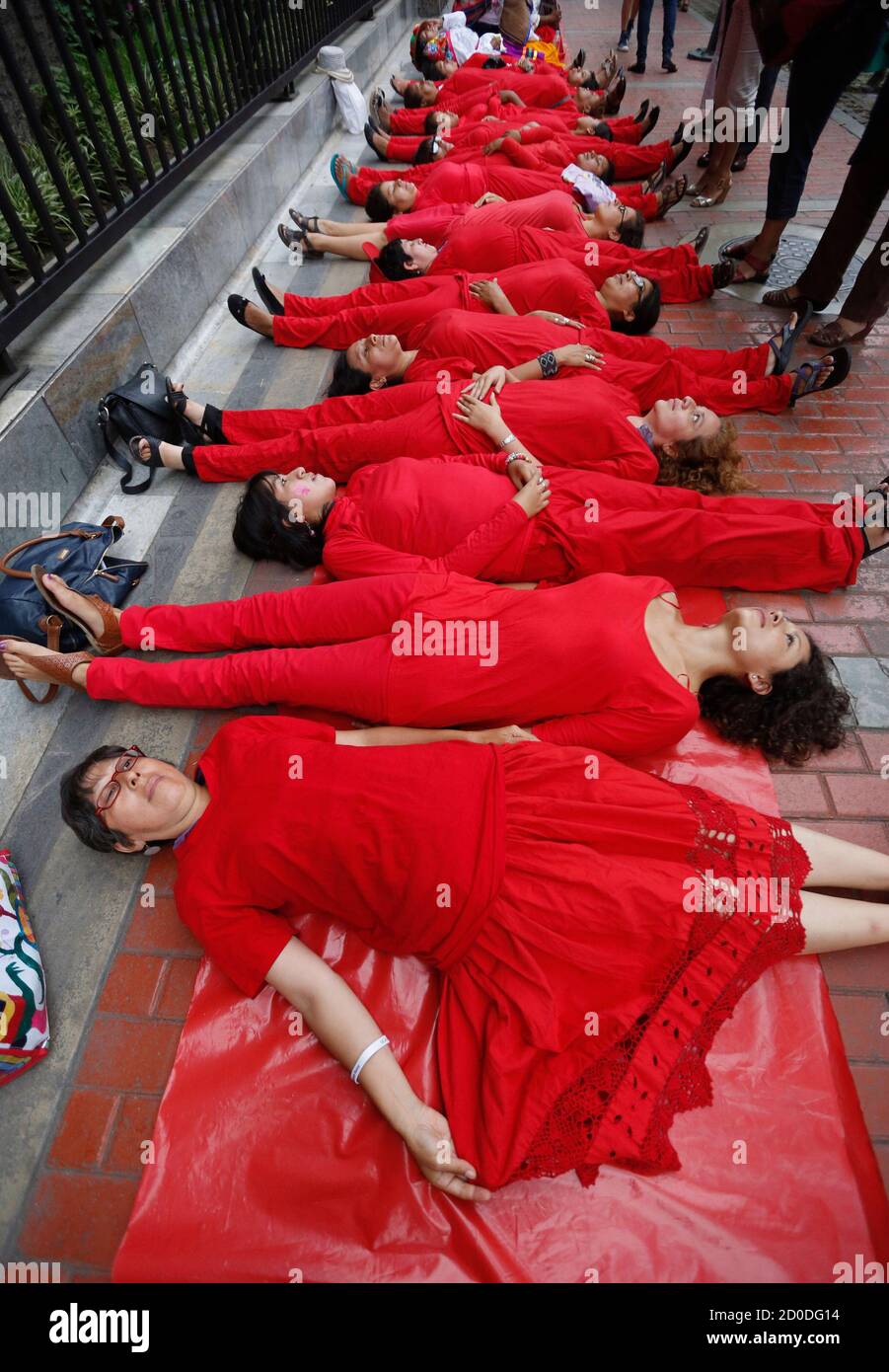 Activists dressed in red protest in front of the Ministry of Women,  representing a human "red carpet" to symbolize women's rights being  trampled by the government, during International Women's Day in Lima