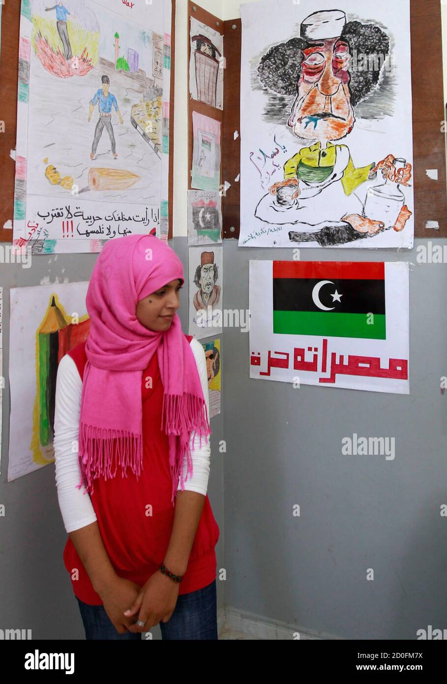 A Libyan girl stands in front a caricature of Libyan leader Muammar Gaddafi  in a school in the rebel-held city of Misrata, July 18, 2011.  REUTERS/Thaier al-Sudani (LIBYA - Tags: POLITICS CONFLICT
