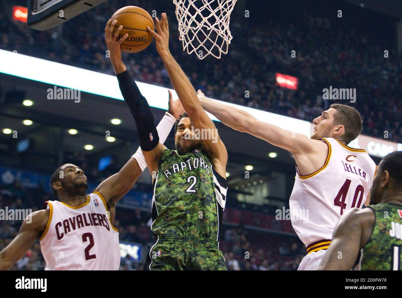 Toronto Raptors Landry Fields goes to the basket between Cleveland  Cavaliers Kyrie Irving (L) and Tyler Zeller in the first half of their NBA  basketball game in Toronto January 26, 2013. The