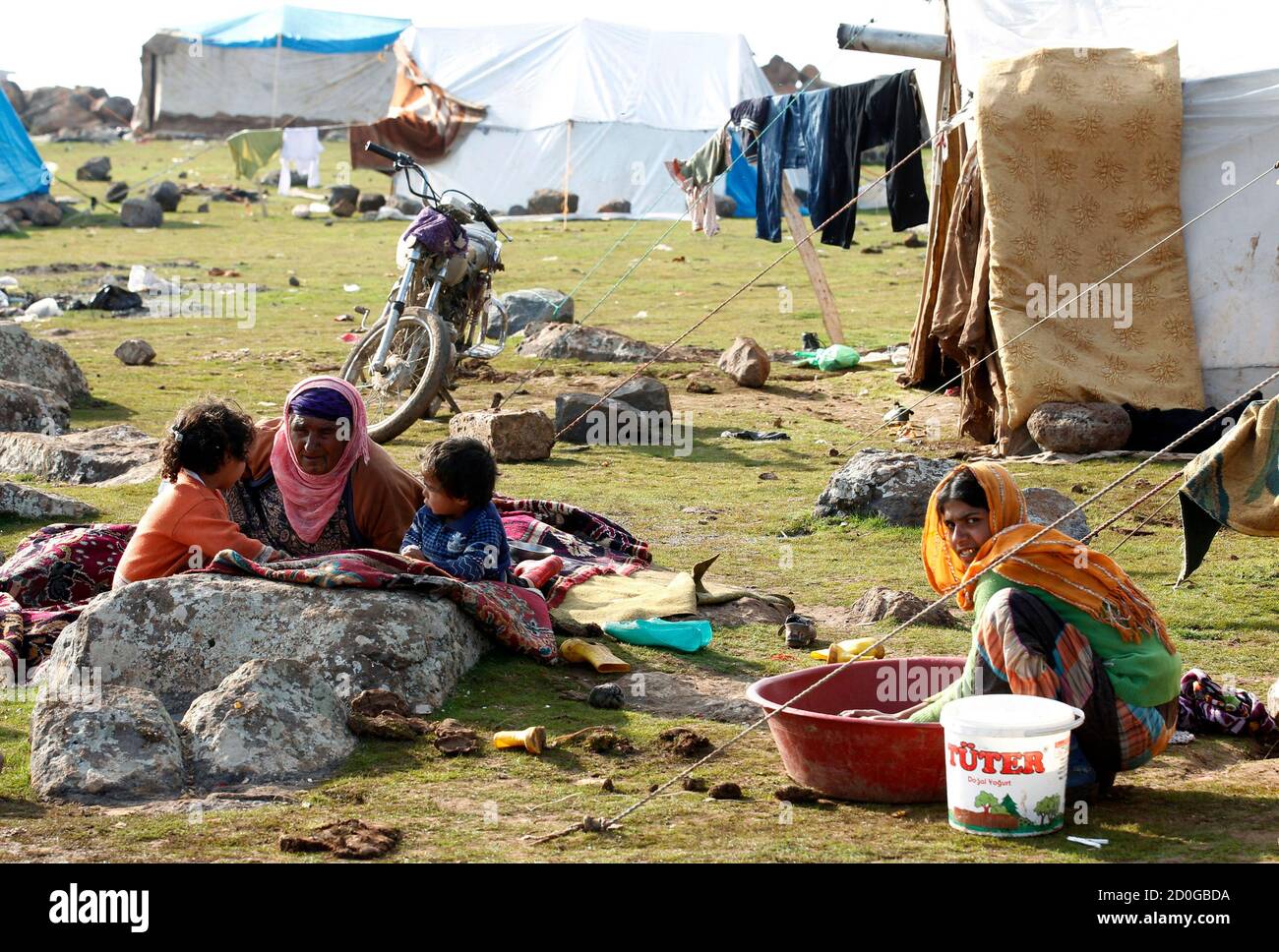 A Syrian refugee woman washes clothes near her family in front of their  makeshift tent in the town of Viransehir in Sanliurfa province, southeast  Turkey, February 10, 2013. Some 50 families, mostly
