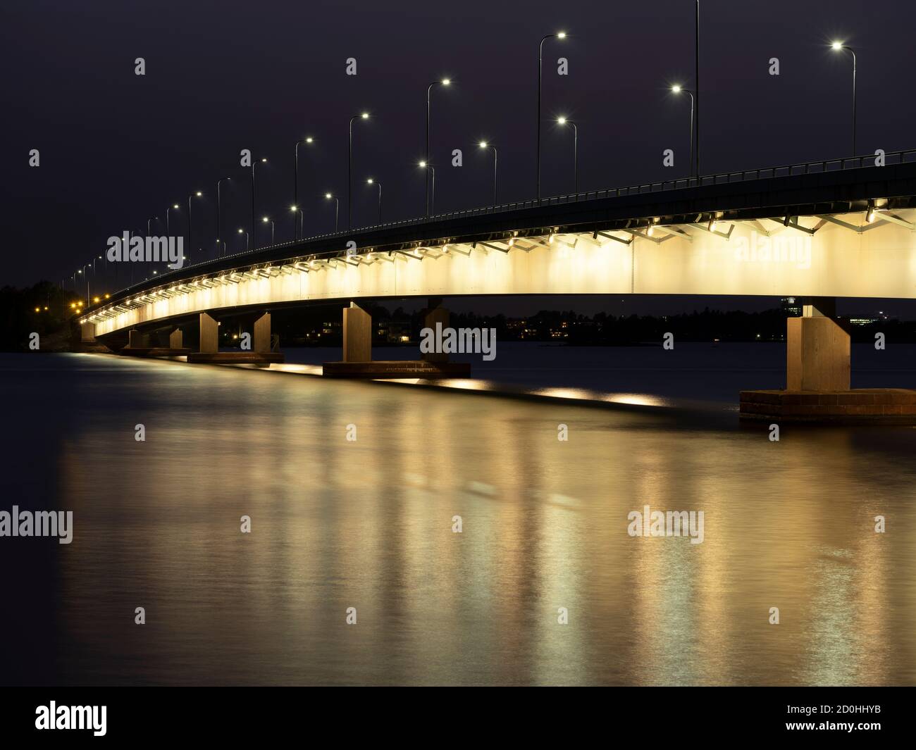 Helsinki/Finlande - 2 OCTOBRE 2020 : un magnifique paysage urbain nocturne d'un pont routier éclairé qui jette des reflets sur l'eau. Banque D'Images