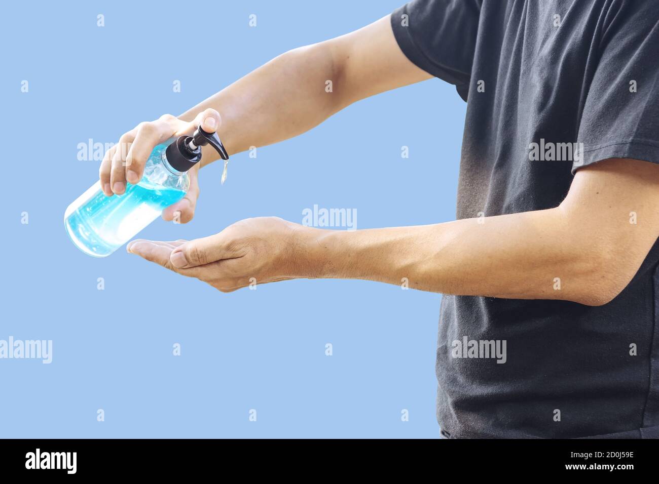 L'homme nettoie ses mains avec du gel d'alcool pour prévenir l'infection par le virus Corona Covid-19, isolé sur fond bleu pastel. Banque D'Images L'homme nettoie ses mains avec du gel d'alcool pour prévenir l'infection par le virus Corona Covid-19, isolé sur fond bleu pastel. Banque D'Images