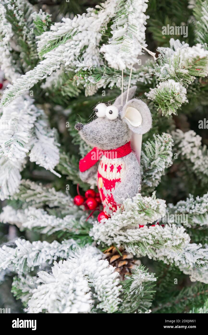 Symbole de l'année 2020. Rat jouet blanc dans un chapeau de noël suspendu sur un arbre en fourrure enneigé. Décoration intérieure festive. Banque D'Images