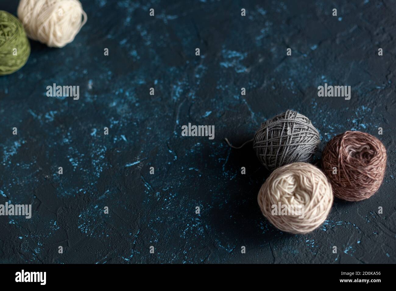 Balles de couleur pelote de fil de laine pour crochet et tricotage sur béton de mastic de texture bleu foncé. Mettre à plat l'image avec de l'espace pour le texte. Banque D'Images