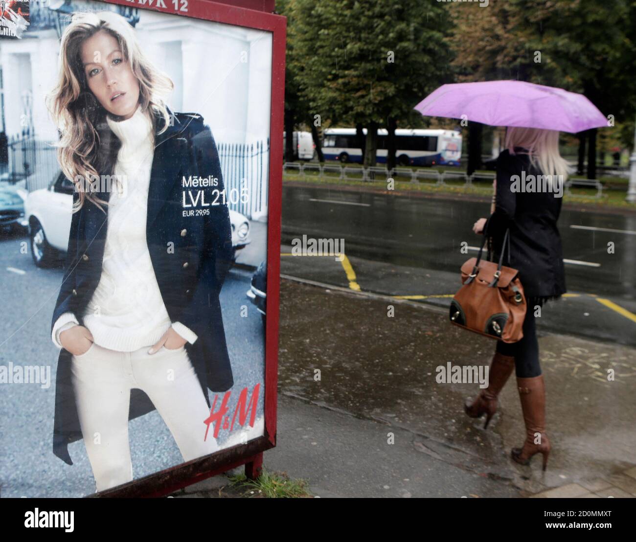 A woman walks past a H&M advertisement in Riga September 25, 2013. Swedish  fashion retailer Hennes & Mauritz looked to put a poor run of form behind  it on Thursday as it