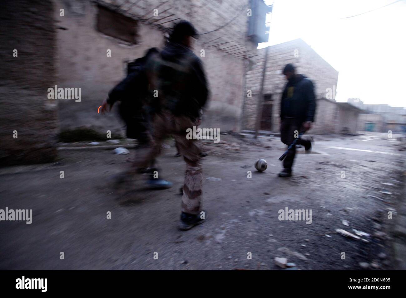 Free Syrian army fighters play football near Al Neirab airport in Aleppo February 17, 2013. REUTERS/Hamid Khatib (SYRIA - Tags: CONFLICT POLITICS CIVIL UNREST) Banque D'Images