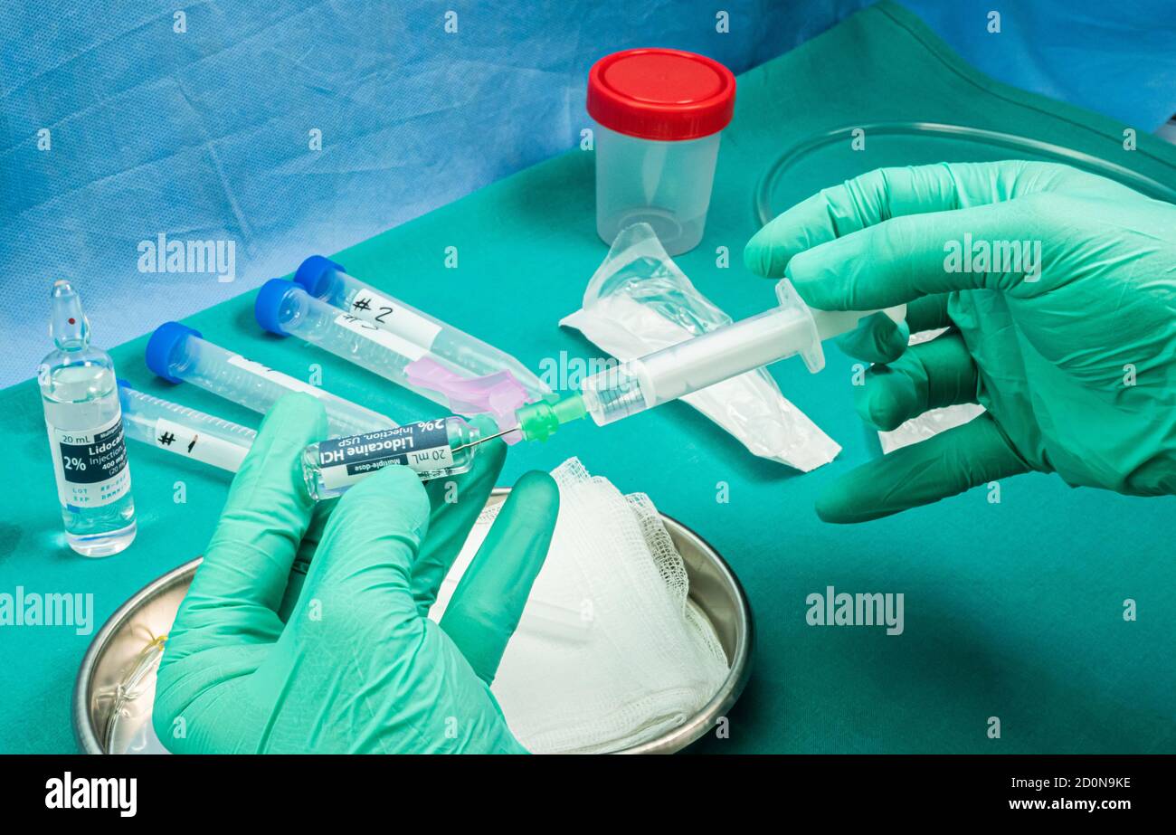 L'infirmière tient une ampoule d'anesthésie, préparation pour extraire le liquide céphalorachidien pour étudier les causes chez une personne atteinte de myélite transversale qui wa Banque D'Images