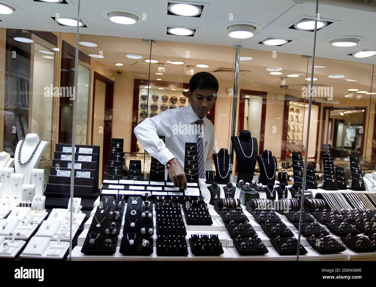A staff member at a jewellery store places a diamond in the window display  at Gold and Diamond Park, a shopping mall specialized in gold and diamond  retailing, in Dubai November 15,
