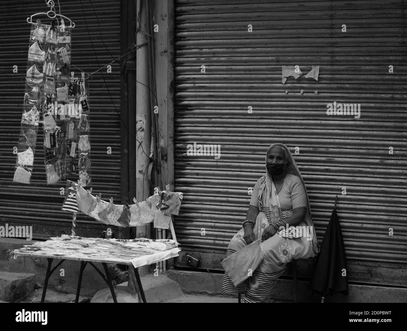 L'image en noir et blanc d'une vieille femme se vend Masques de subsistance après une pandémie en Inde Banque D'Images
