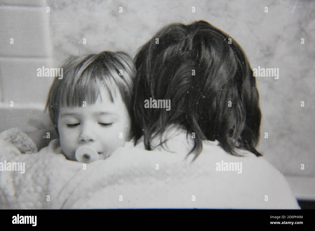 Belle photographie vintage en noir et blanc des années 1970 d'une mère parenting sa jeune fille à travers ses problèmes émotionnels et croissants. Banque D'Images