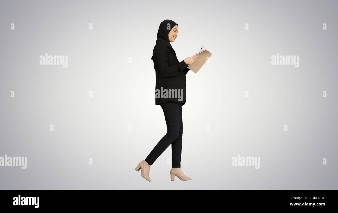 Surprise femme d'affaires musulmane lisant le journal d'affaires et de s'en tenir Banque D'Images