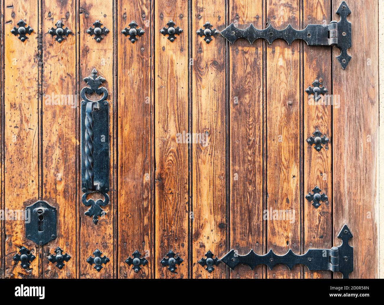 Détails de la porte médiévale en bois de palais avec des décorations en fer forgé.lumière bois usé par le temps Banque D'Images