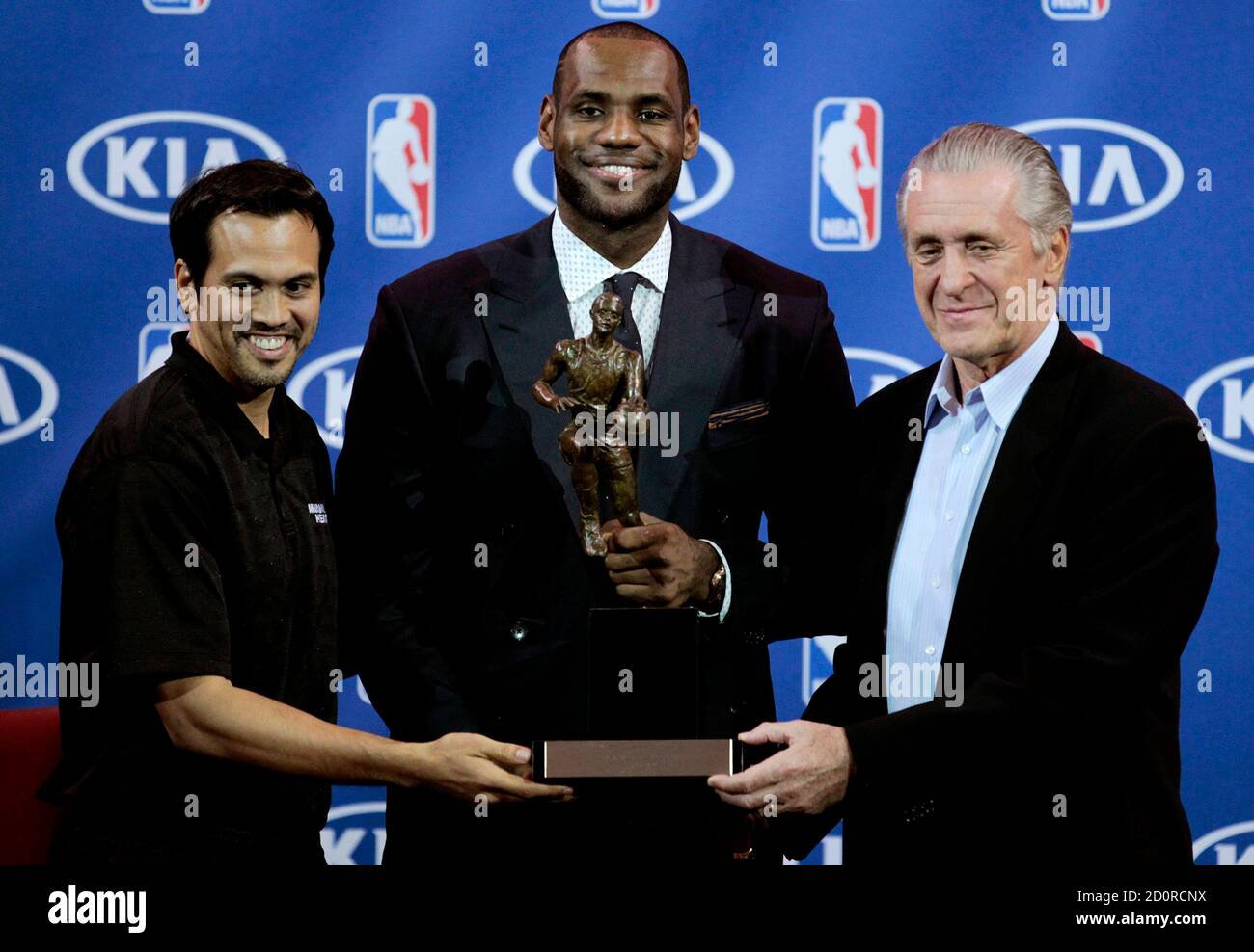 Miami Heat forward LeBron James (C) holds the trophy as he stands with head  coach Erik Spoelstra (L) and team president Pat Riley, after being named NBA  Most Valuable Player at a
