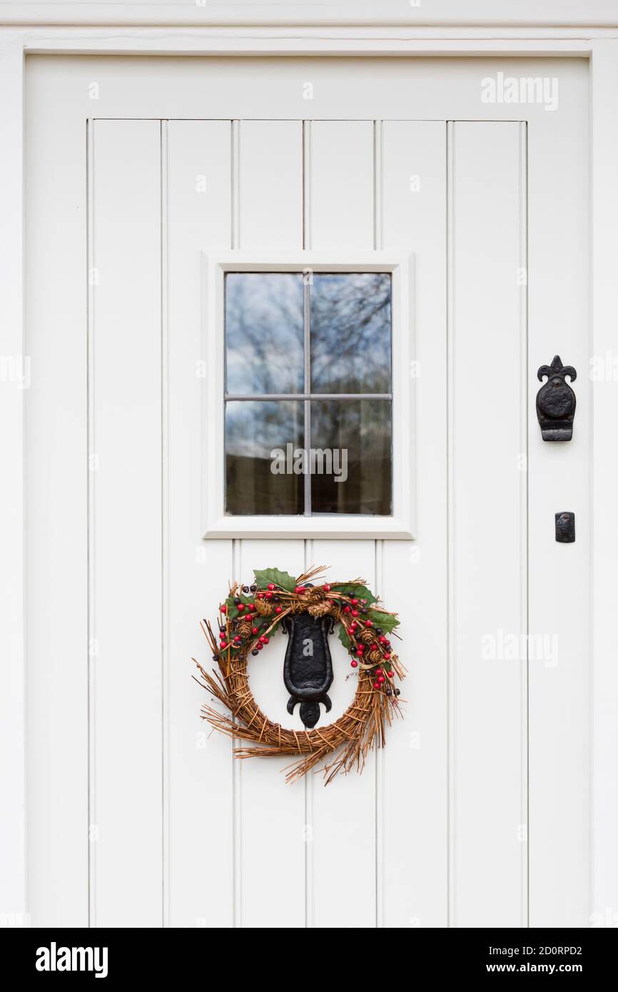 Porte avant en bois peint blanc cassé, blanc cassé, gris et gris avec verre au plomb et guirlande de Noël, Royaume-Uni Banque D'Images