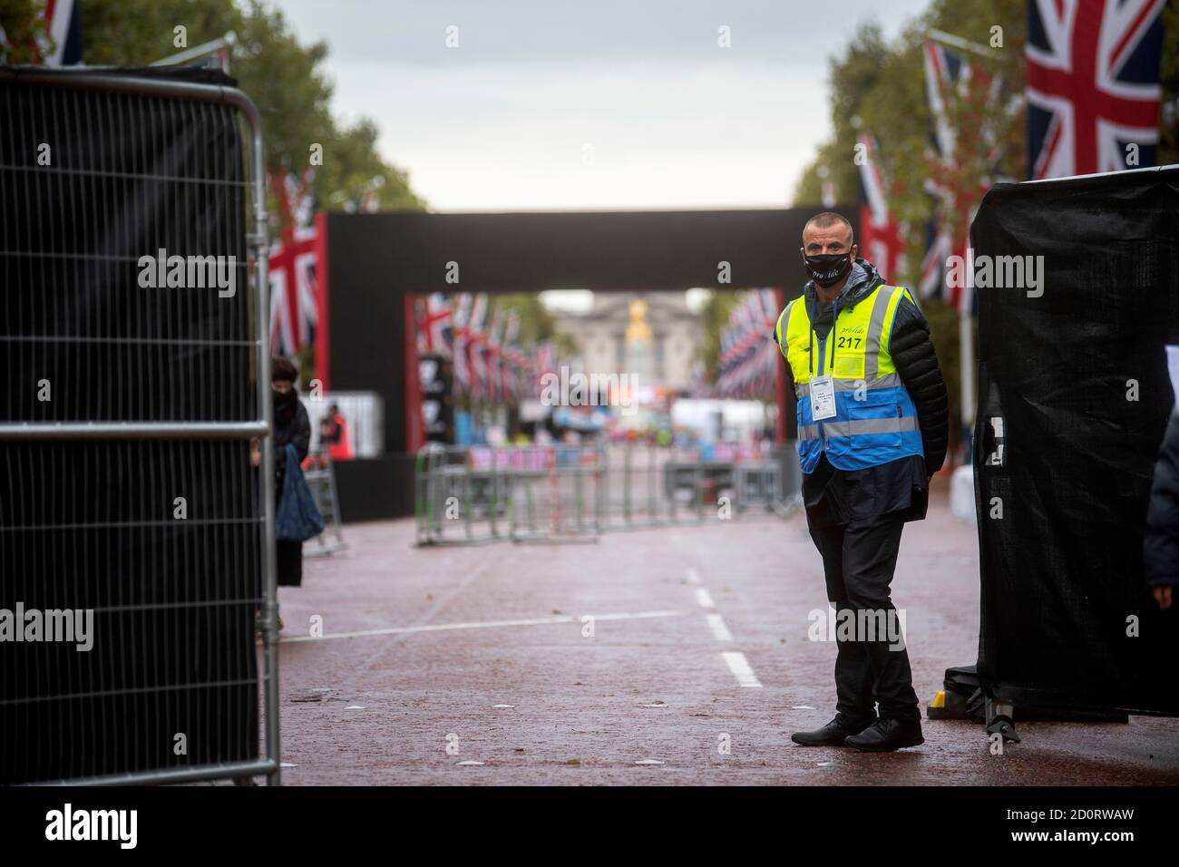 Un agent de sécurité se trouve à côté de la projection sur le Mall, ce qui empêchera les spectateurs d'assister au 40ème marathon de Londres, qui se déroulera sur un circuit fermé autour du parc St James's dans le centre de Londres. Les athlètes participant aux courses d'élite pour hommes, femmes et fauteuils roulants participeront à un cours en boucle fermé dans le parc St James's, dans une bulle de biosecure. Banque D'Images