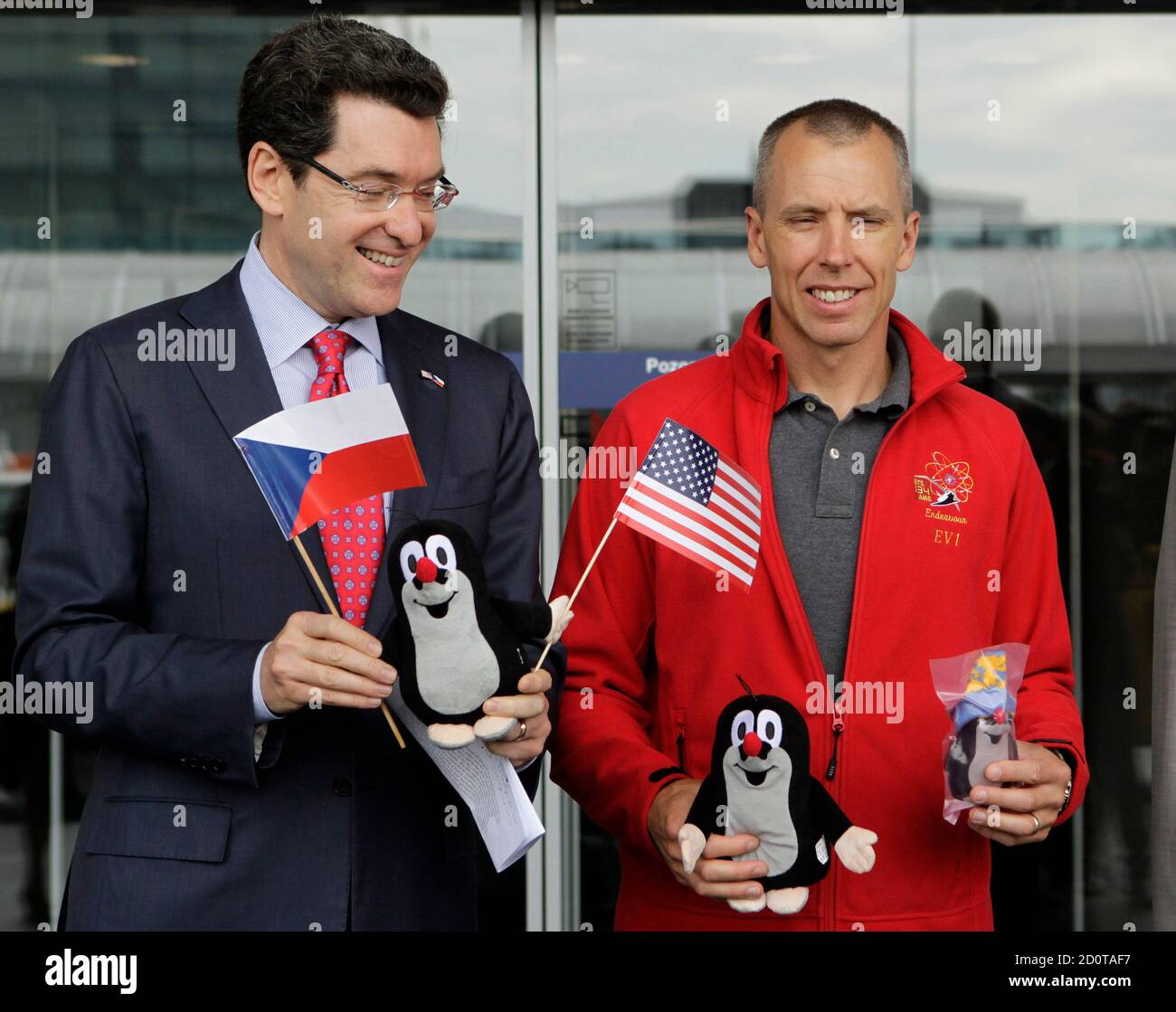 U.S. ambassador to the Czech Republic Norman L. Eisen (L) and U.S.  astronaut Andrew Feustel hold stuffed toys of Krtek the Mole, a well-known  figure from the Czech animated cartoon series, at