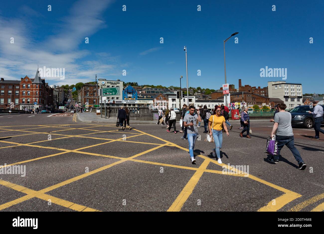 Cork City, Irlande - 18 mai 2018 : personnes traversant la rue sur Merchant's Quay en face du pont St Patricks dans le centre-ville de Cork sur un sprin ensoleillé Banque D'Images