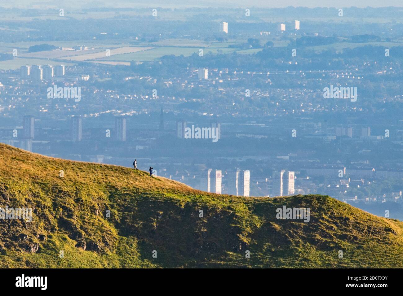 Marcheurs dans les CAMPSIE Fells surplombant les gratte-ciels lointains de Glasgow, en Écosse, au Royaume-Uni Banque D'Images