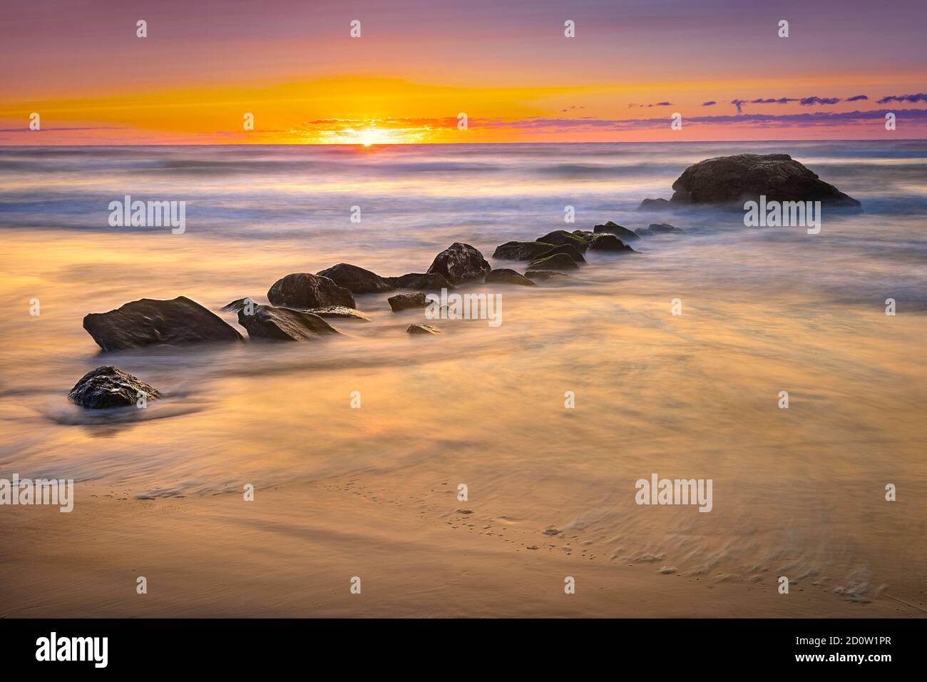 Vagues brumeuses et surf avec des rochers au lever du soleil, Narragansett, Rhode Island USA Banque D'Images