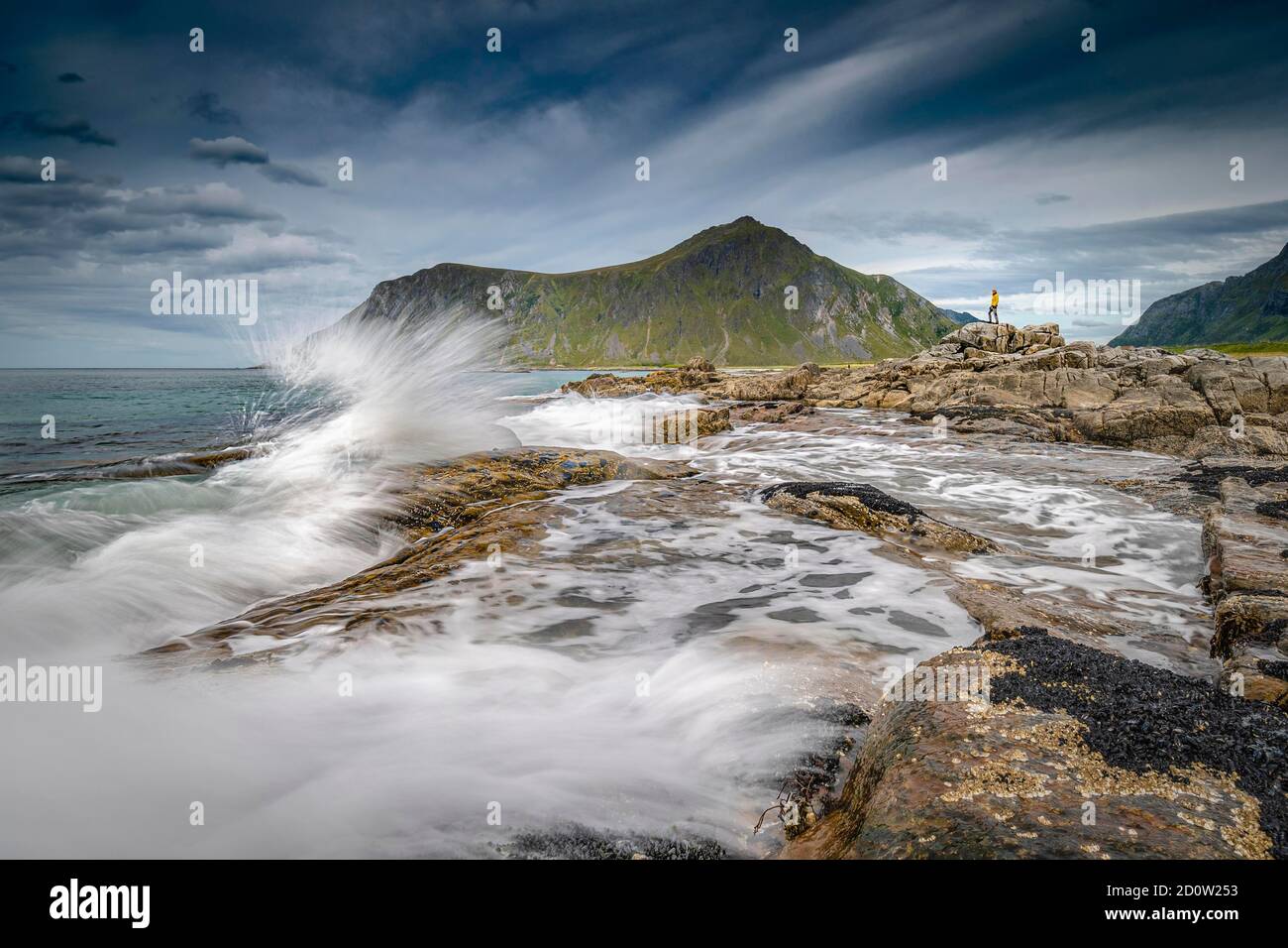 Personne minuscule sur les rochers et regardant la mer surf, plage à Flakstad, Flakstadøy, Skagsanden, Flakstad, Lofoten, Nordland, Norvège, Europe Banque D'Images