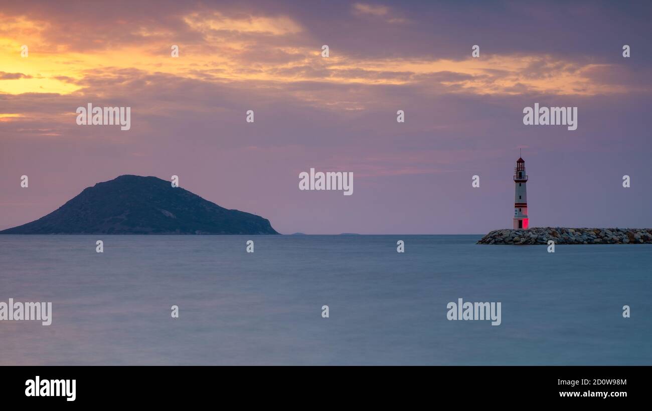 Un coucher de soleil tranquille et un phare rouge sur la côte de mer Aegian Bodrum, Turquie Banque D'Images