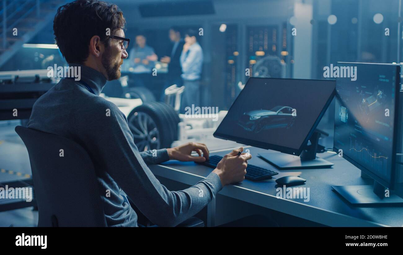 Professional Automotive Graphic Designer travaille sur le concept car Render Avec un stylet dans un laboratoire innovant de haute technologie Avec une voiture prototype Banque D'Images